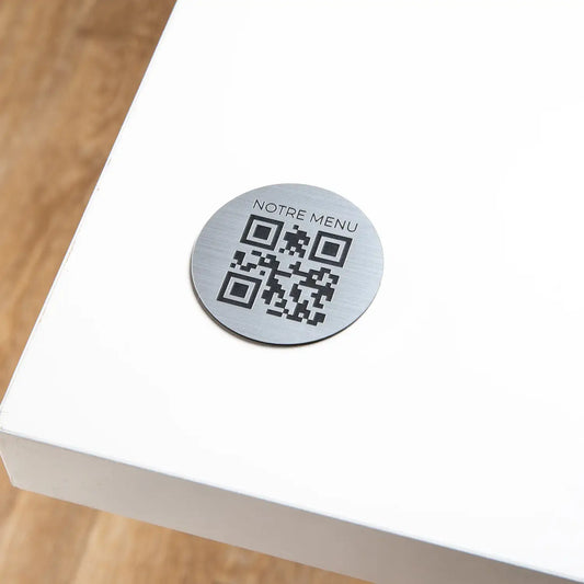 Round engraved QR code plate with phrase at the top