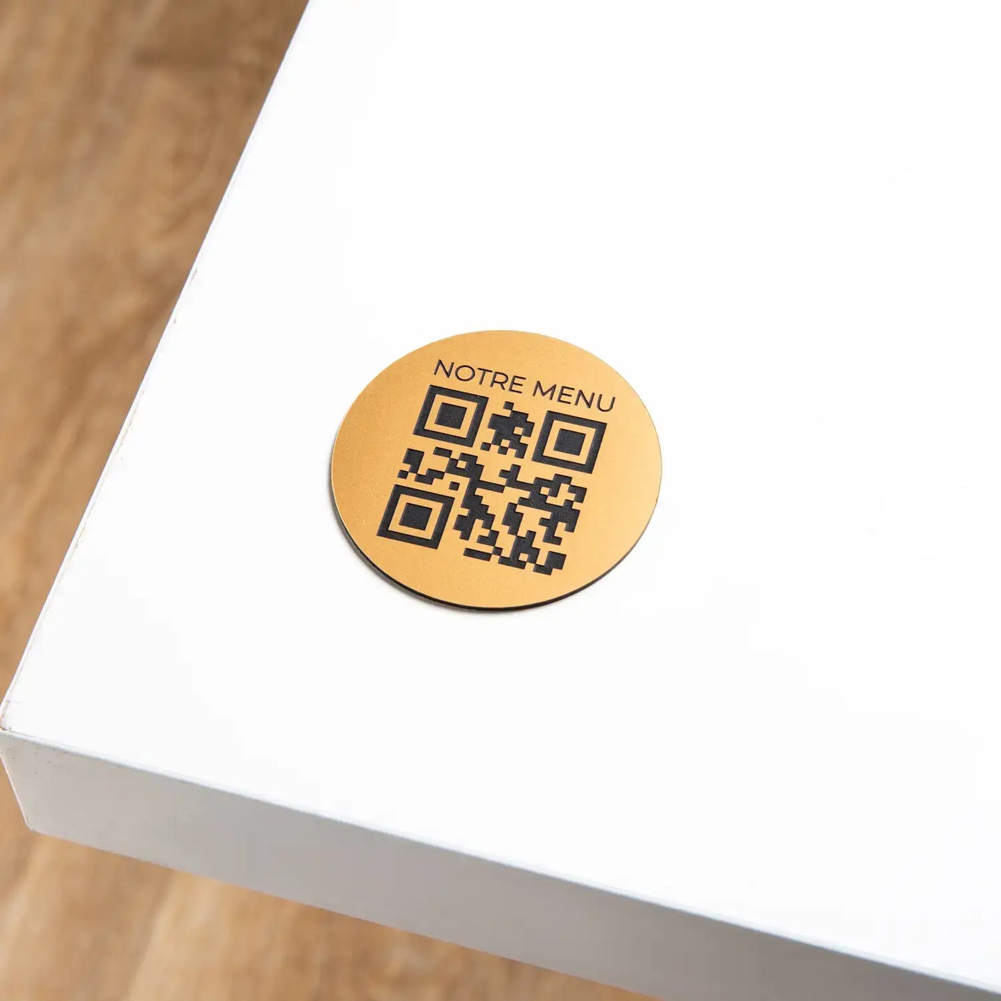 Round engraved QR code plate with phrase at the top
