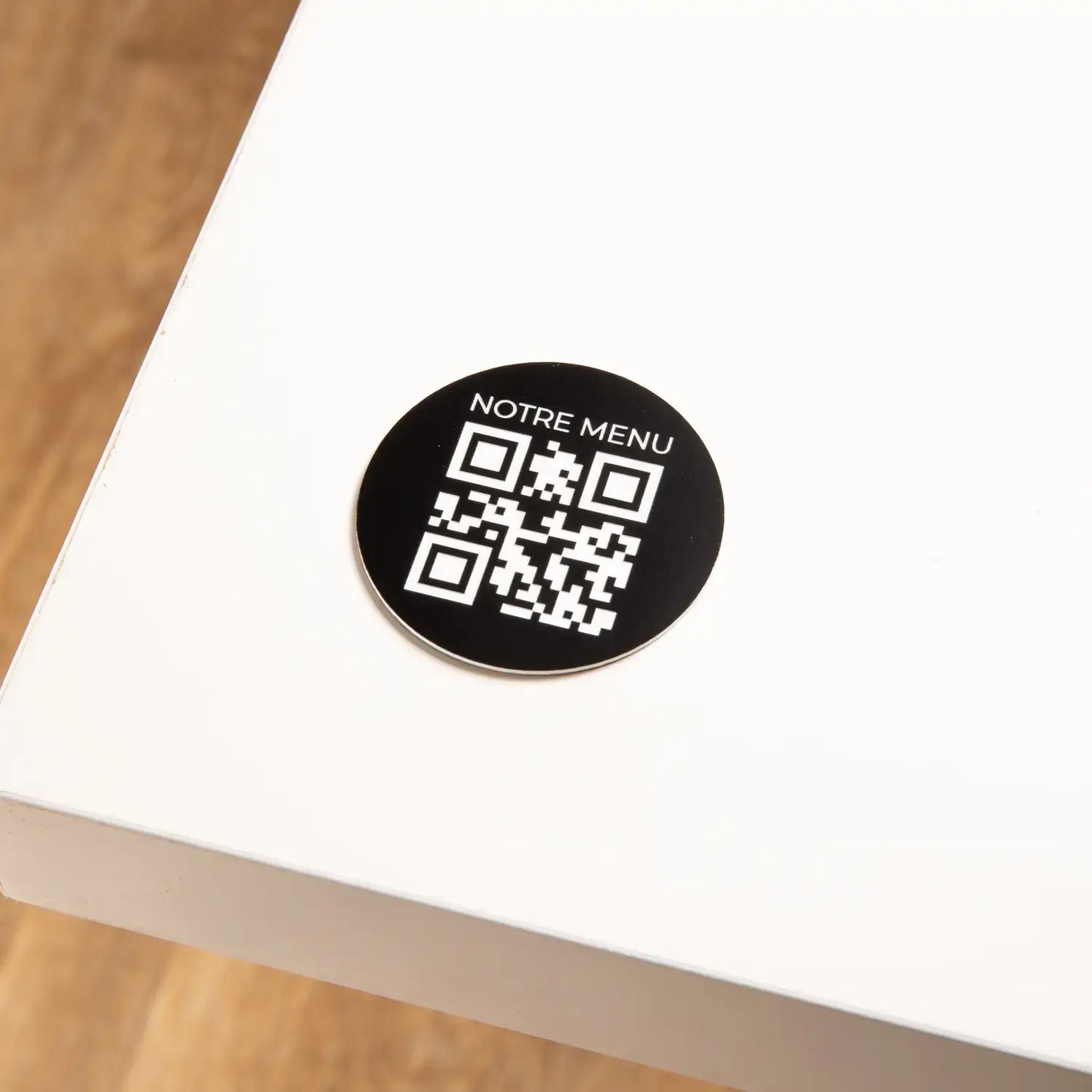 Round engraved QR code plate with phrase at the top