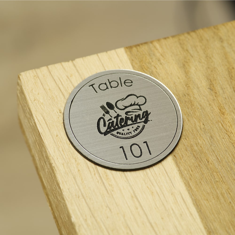 numéro de table rond avec logo du restaurant gravé en argent